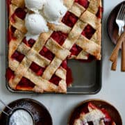 A top-down view of a Strawberry Slab Pie with lattice topped with three scoops of vanilla ice cream.