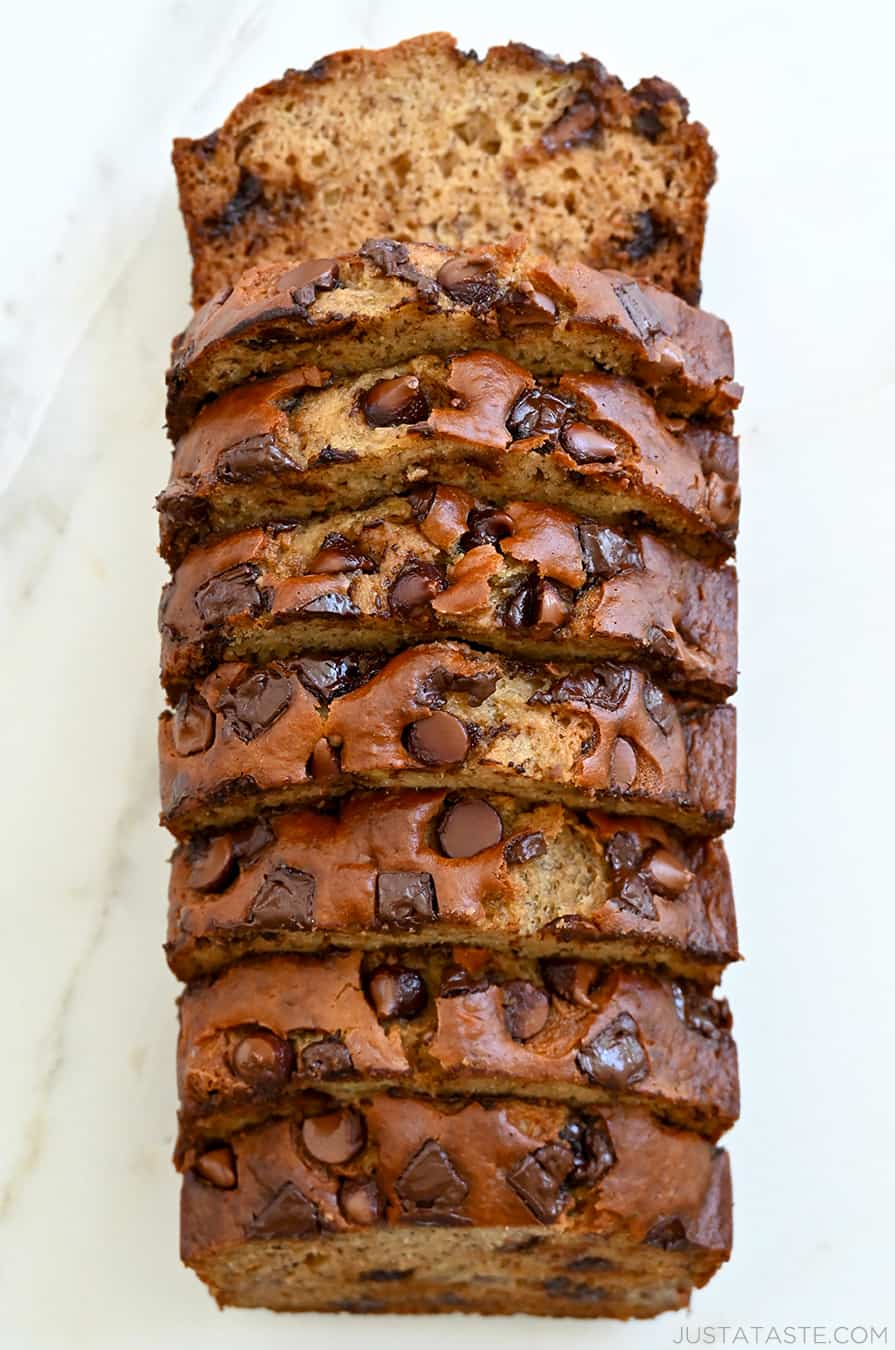 A top-down view of a sliced loaf of Buttermilk Banana Bread studded with chocolate chunks