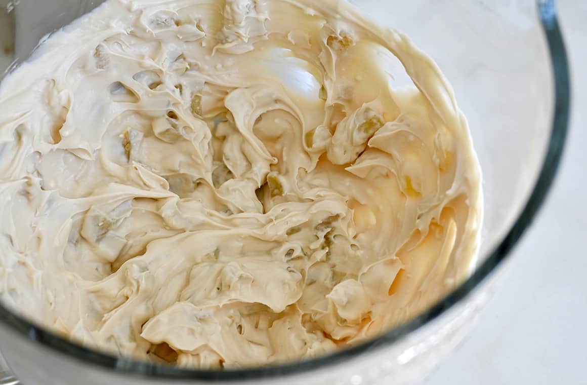 Creamy dip in a clear bowl of a stand mixer