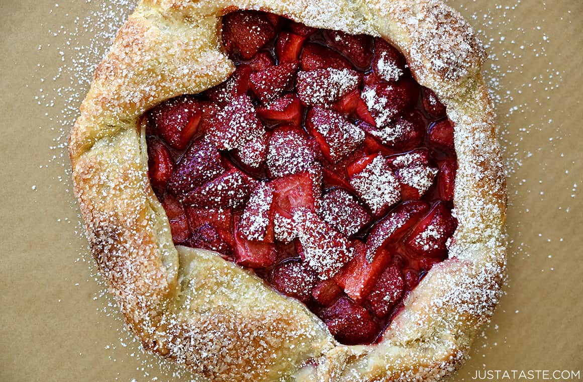 A top-down view of a golden brown galette made with puff pastry and fresh strawberries