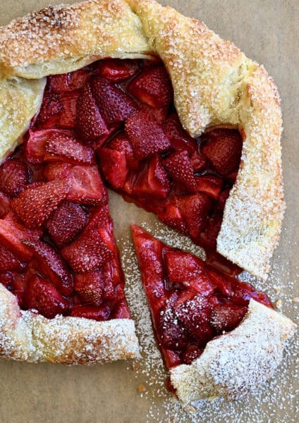 A top-down view of a strawberry puff pastry galette dusted with powered sugar