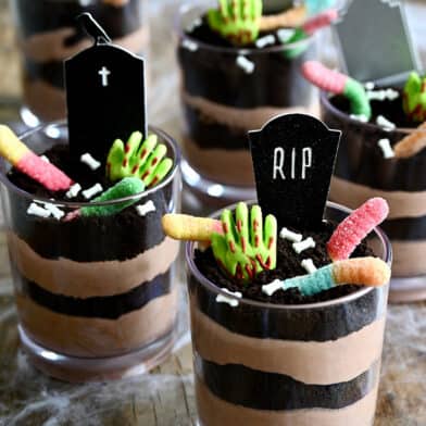 Individual Halloween Dirt Cups with gummy worms, bloody gummy hands and RIP cake toppers