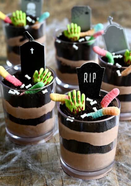 Individual Halloween Dirt Cups with gummy worms, bloody gummy hands and RIP cake toppers