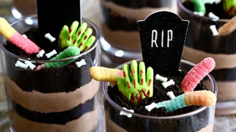 Individual Halloween Dirt Cups with gummy worms, bloody gummy hands and RIP cake toppers