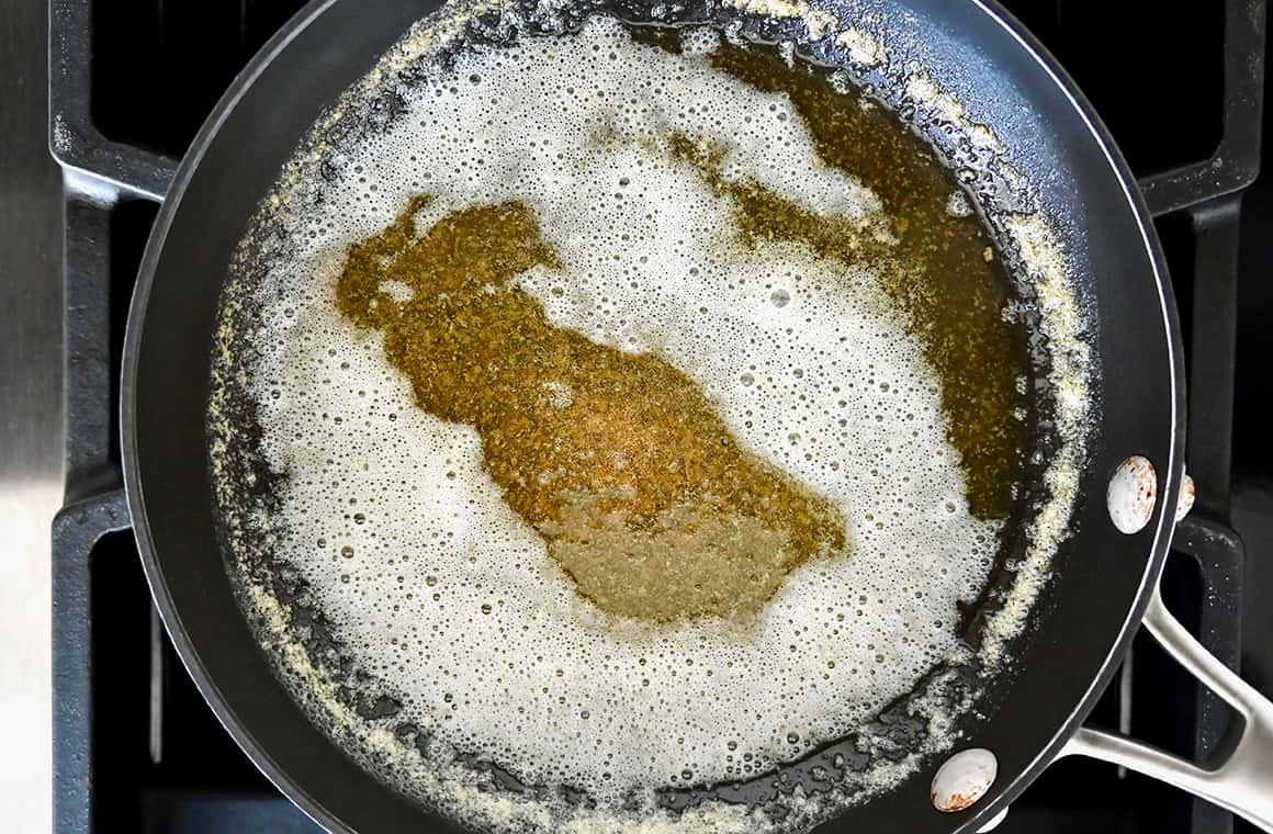 A top-down view of a skillet containing golden butter