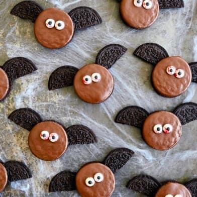 A top-down view of No-Bake Oreo Bat Cookies with bloodshot candy eyes atop fake cobwebs