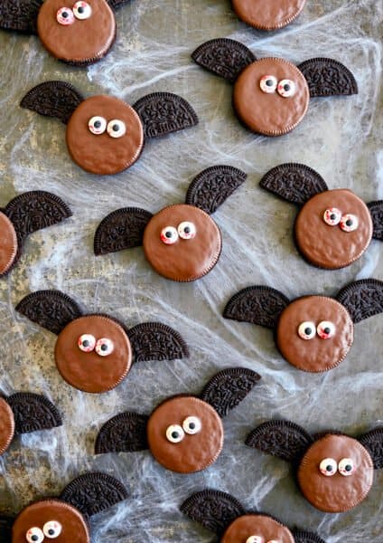 A top-down view of No-Bake Oreo Bat Cookies with bloodshot candy eyes atop fake cobwebs