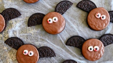 A top-down view of No-Bake Oreo Bat Cookies with bloodshot candy eyes atop fake cobwebs