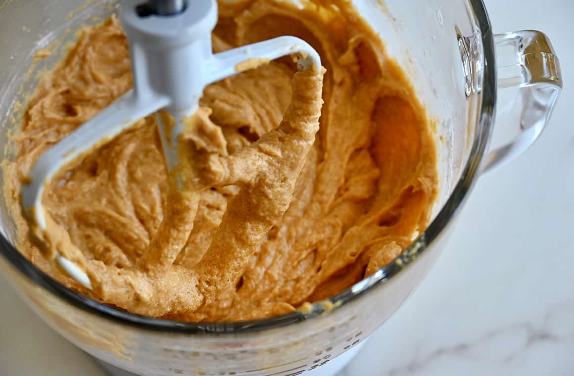 Pumpkin bread batter in a bowl of a stand mixer with the paddle attachment