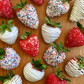 A top-down view of homemade White Chocolate-Covered Strawberries, including some decorated with rainbow sprinkles