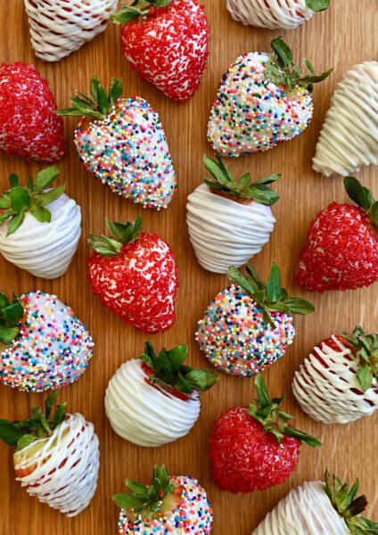 A top-down view of homemade White Chocolate-Covered Strawberries, including some decorated with rainbow sprinkles