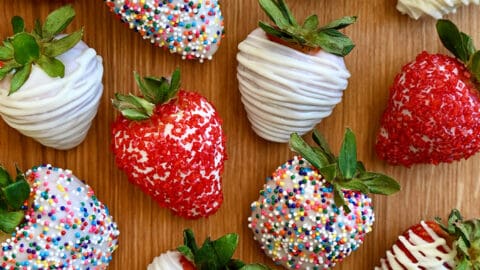 A top-down view of homemade White Chocolate-Covered Strawberries, including some decorated with rainbow sprinkles