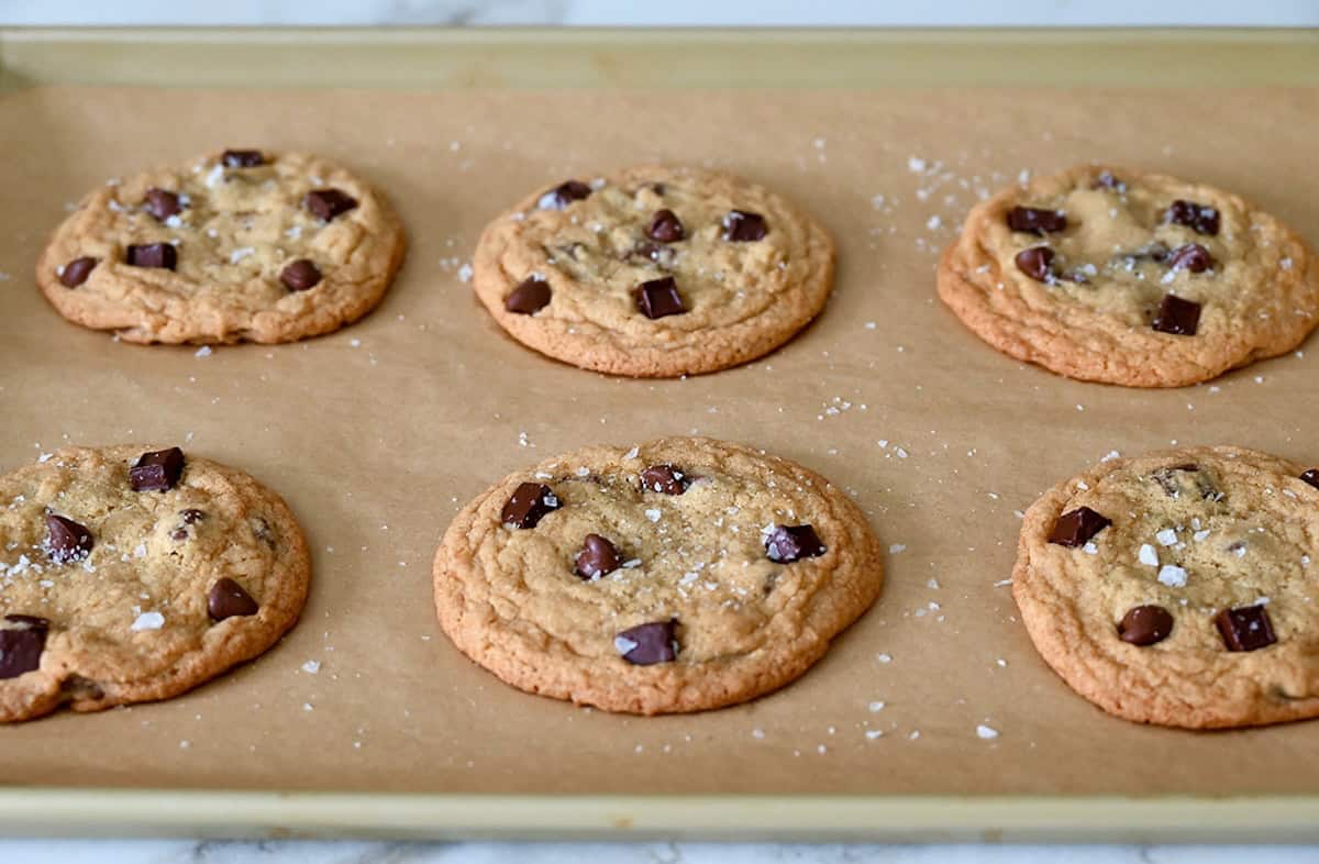 Freshly baked soft chocolate chip cookies sprinkled with large-flake sea salt.
