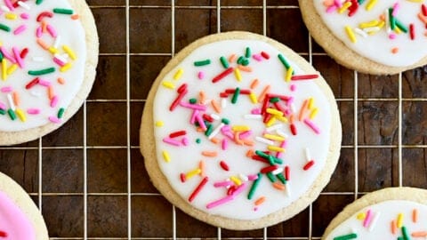 A closeup view of homemade sugar cookies frosted with the best sugar cookie icing in vibrant pink and bright white