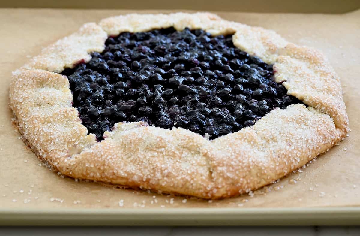 Golden brown blueberry galette with a sanding sugar crust.