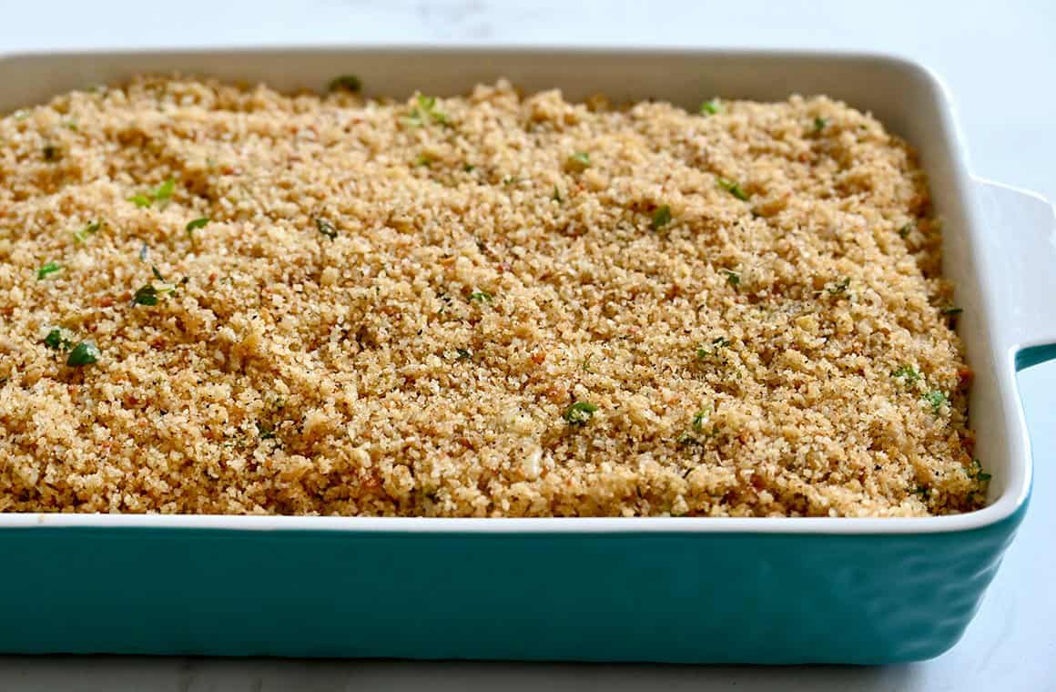 A large baking dish containing casserole topped with breadcrumbs