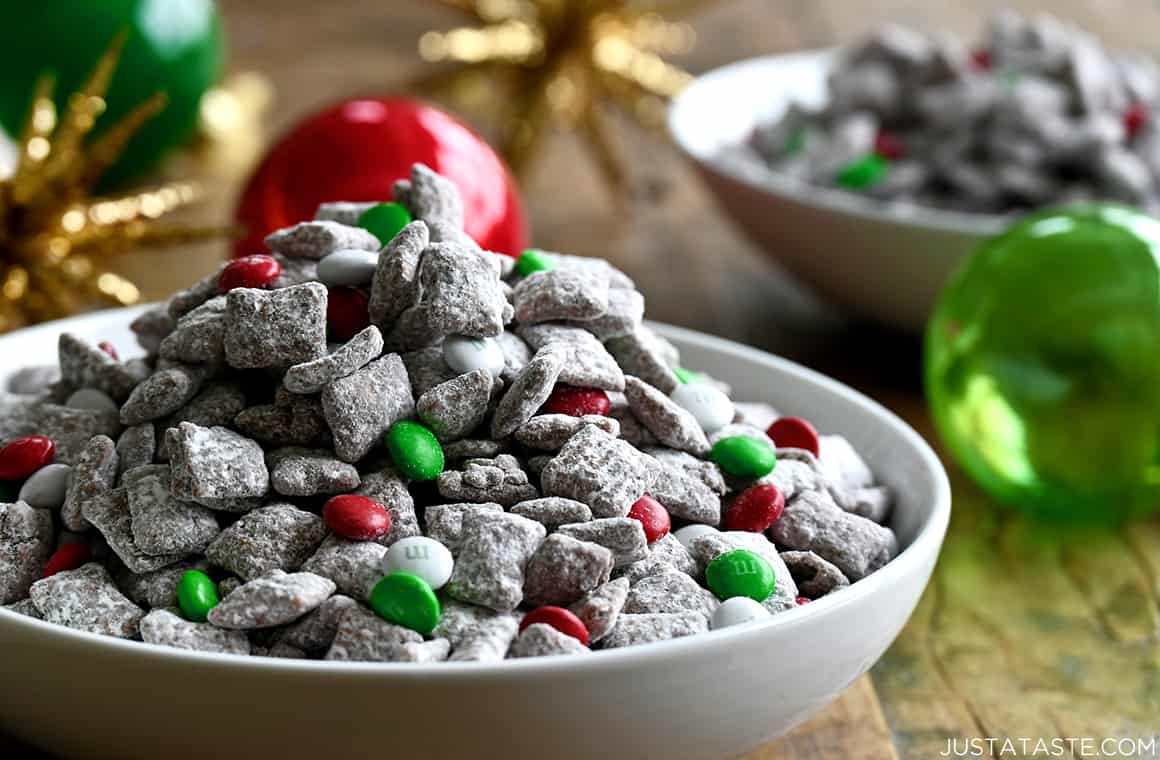 Christmas Puppy Chow with holiday M&Ms in a white serving bowl