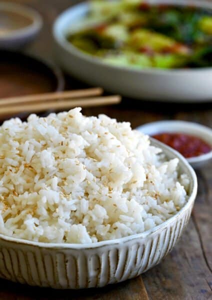 A bowl containing the best creamy coconut rice garnished with white sesame seeds