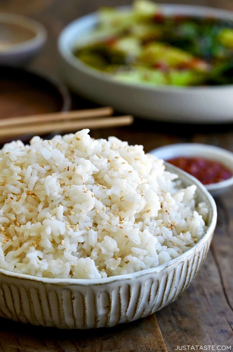 A bowl containing the best creamy coconut rice garnished with white sesame seeds