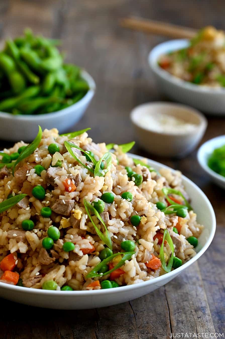 A white bowl containing Pork Fried Rice with peas and carrots