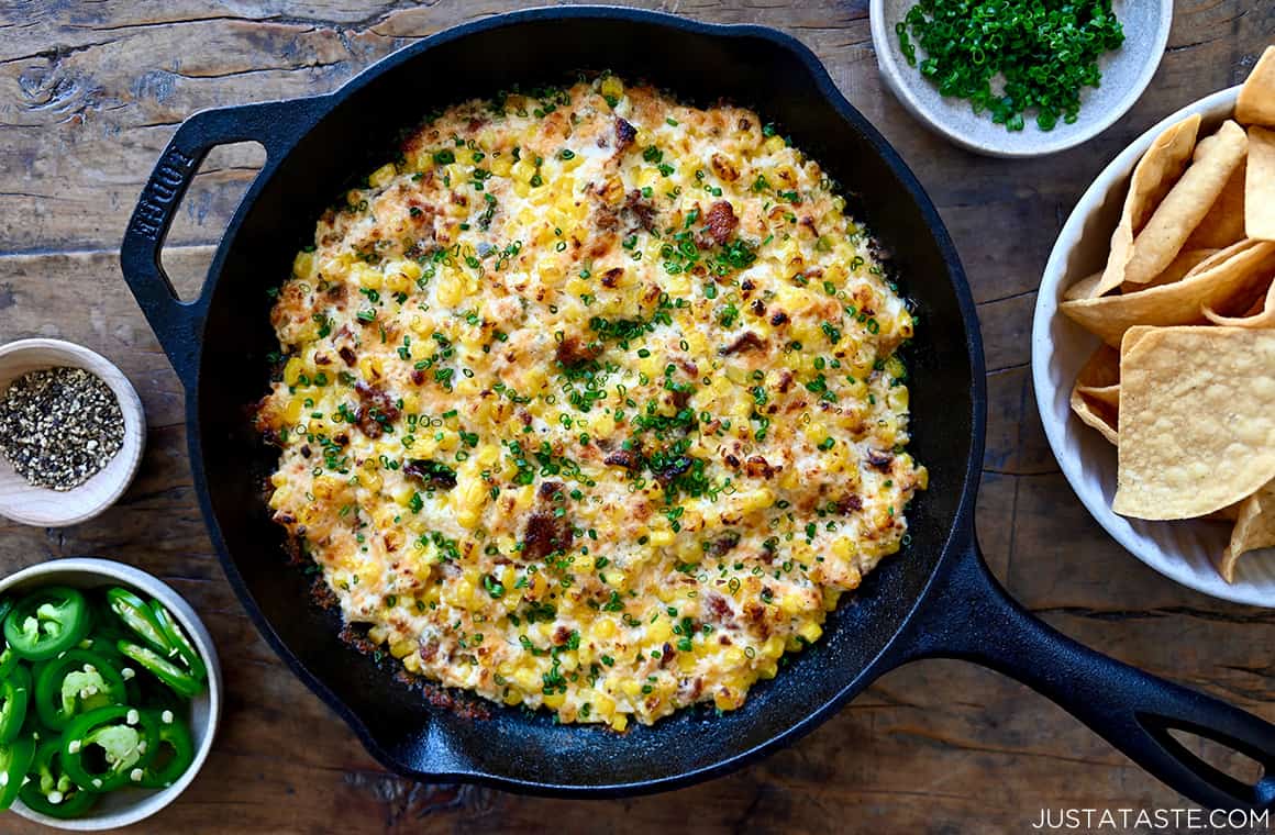 A top-down view of a cast iron skillet with the best corn dip with bacon and jalapeño 