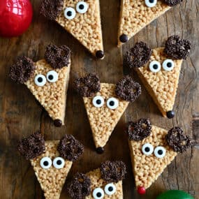 A top-down view of adorable Reindeer Rice Krispies Treats with candy eyes and chocolate-covered pretzels for antlers