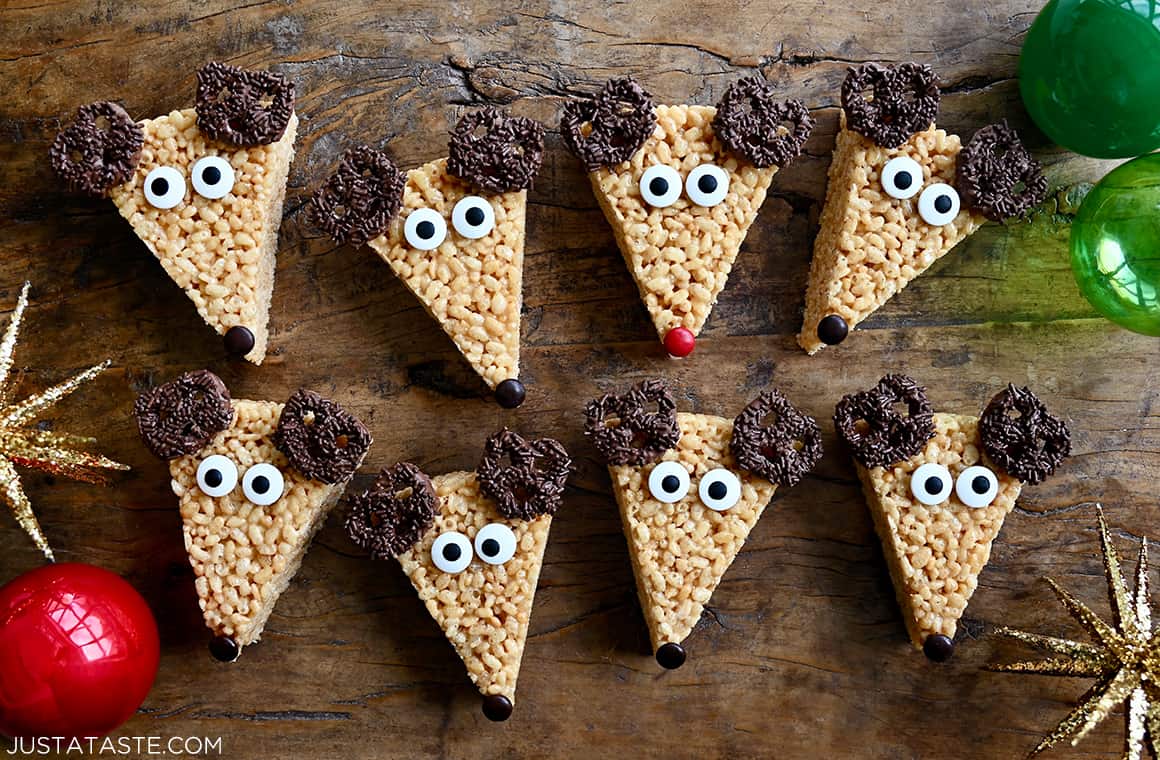 A top-down view of easy Reindeer Rice Krispie Treats with candy eyes and chocolate-covered pretzel "antlers"