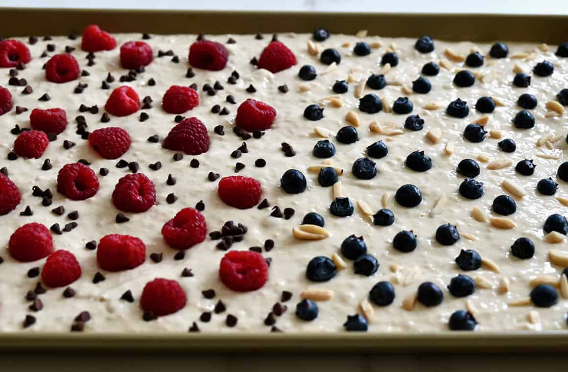 Batter topped with fresh raspberries, blueberries mini chocolate chips and peanuts