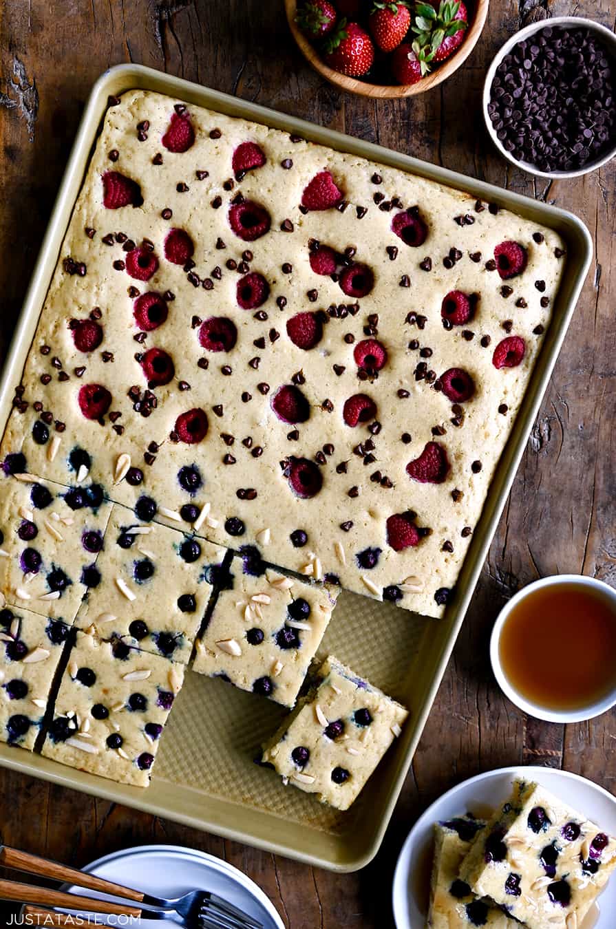 A top-down view of sheet pan pancakes topped with fresh berries and nuts