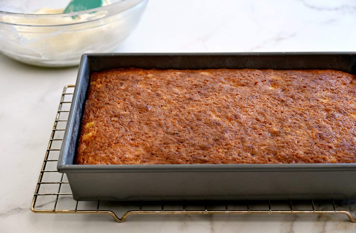 A sheet cake cooling atop a wire rack