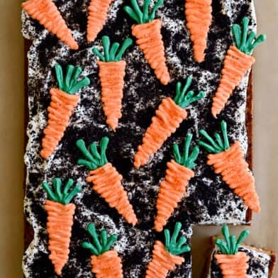 A top-down view Carrot Sheet Cake with Cream Cheese Frosting, Oreo dirt and candy melt carrots