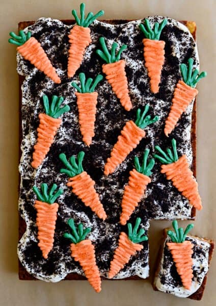 A top-down view Carrot Sheet Cake with Cream Cheese Frosting, Oreo dirt and candy melt carrots