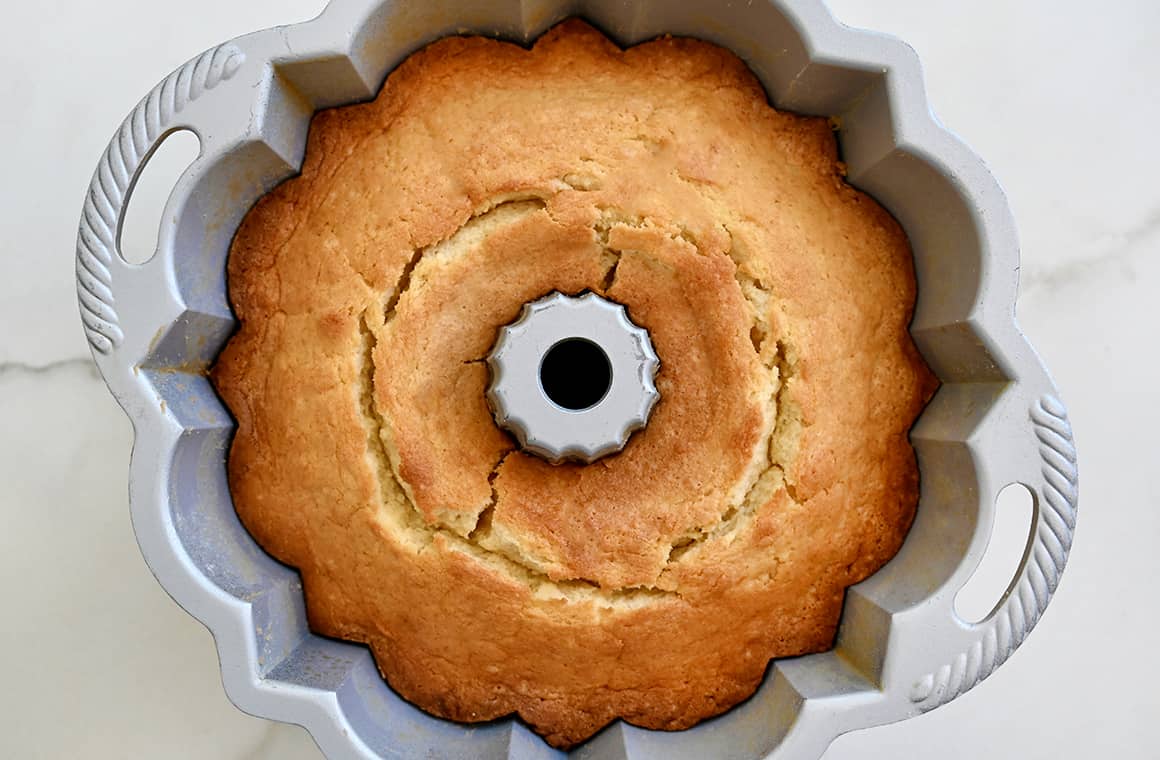 A top-down view of a golden brown cake in a bundt pan