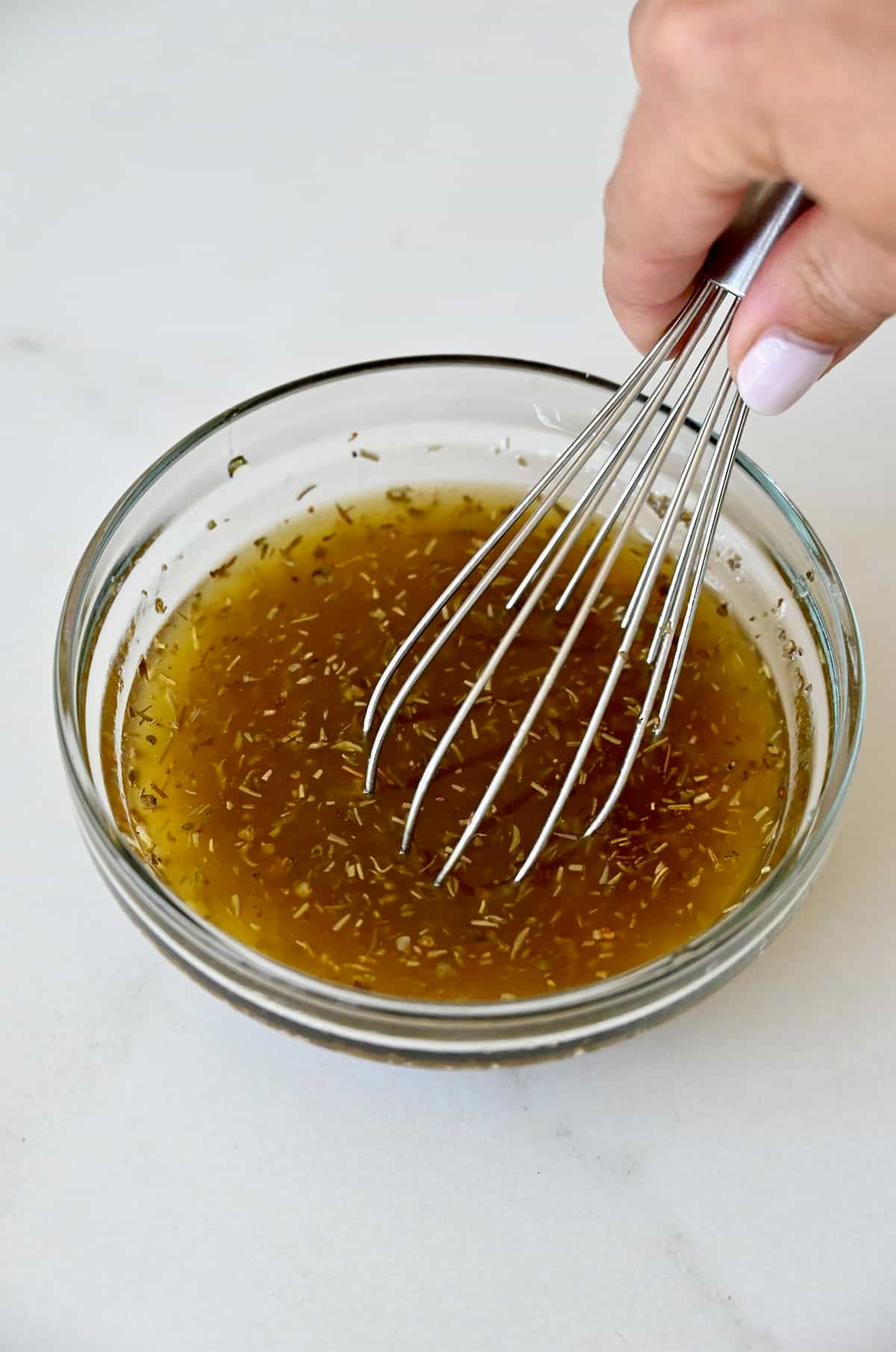 Lemon red wine vinaigrette in a small bowl with a whisk.