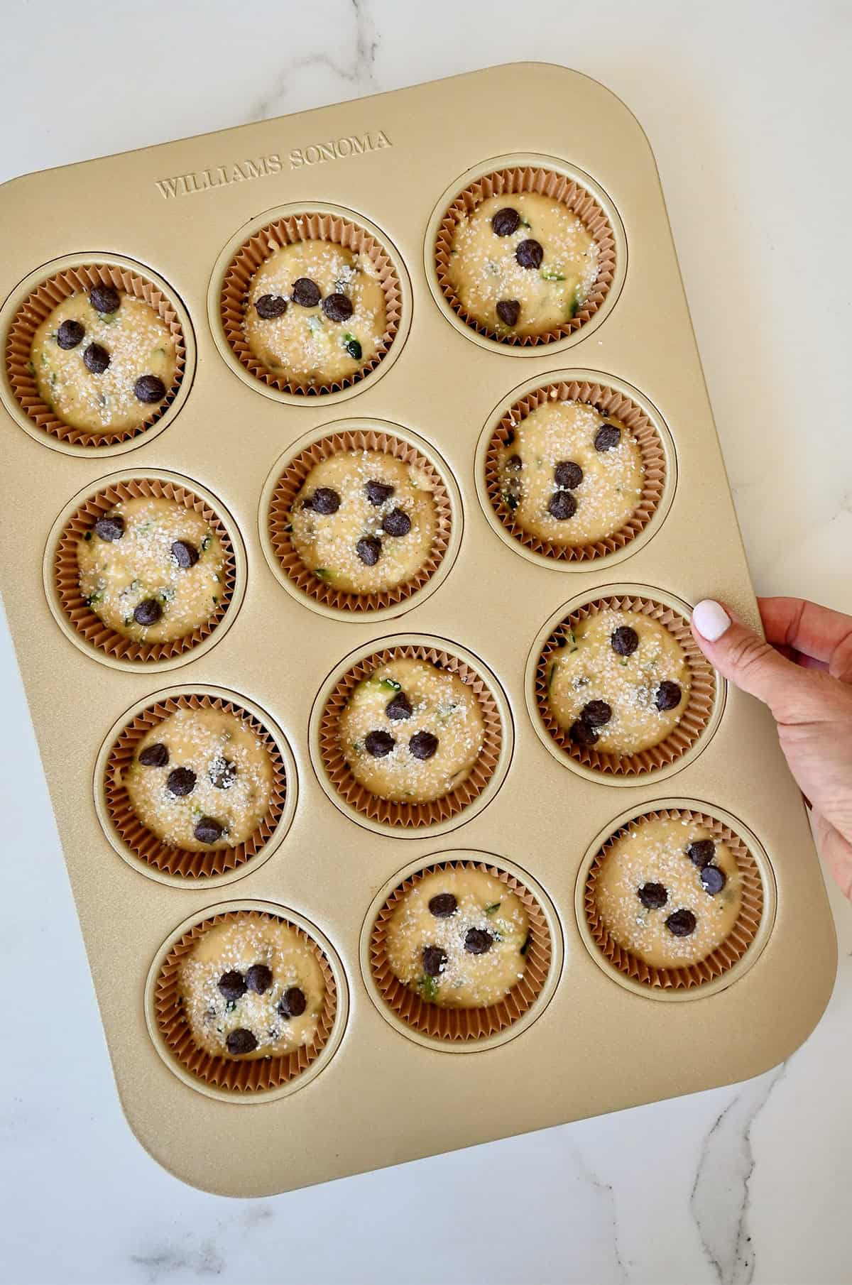Unbaked zucchini muffins in a standard 12-cup muffin pan.