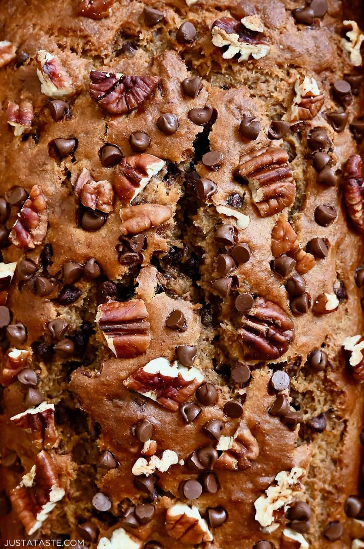Healthy whole wheat banana bread topped with chopped pecans and mini chocolate chips.