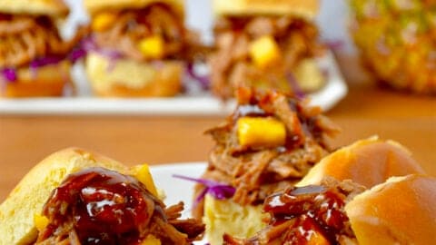 Slow cooker Hawaiian pulled pork with pineapple chunks and barbecue sauce on slider buns.