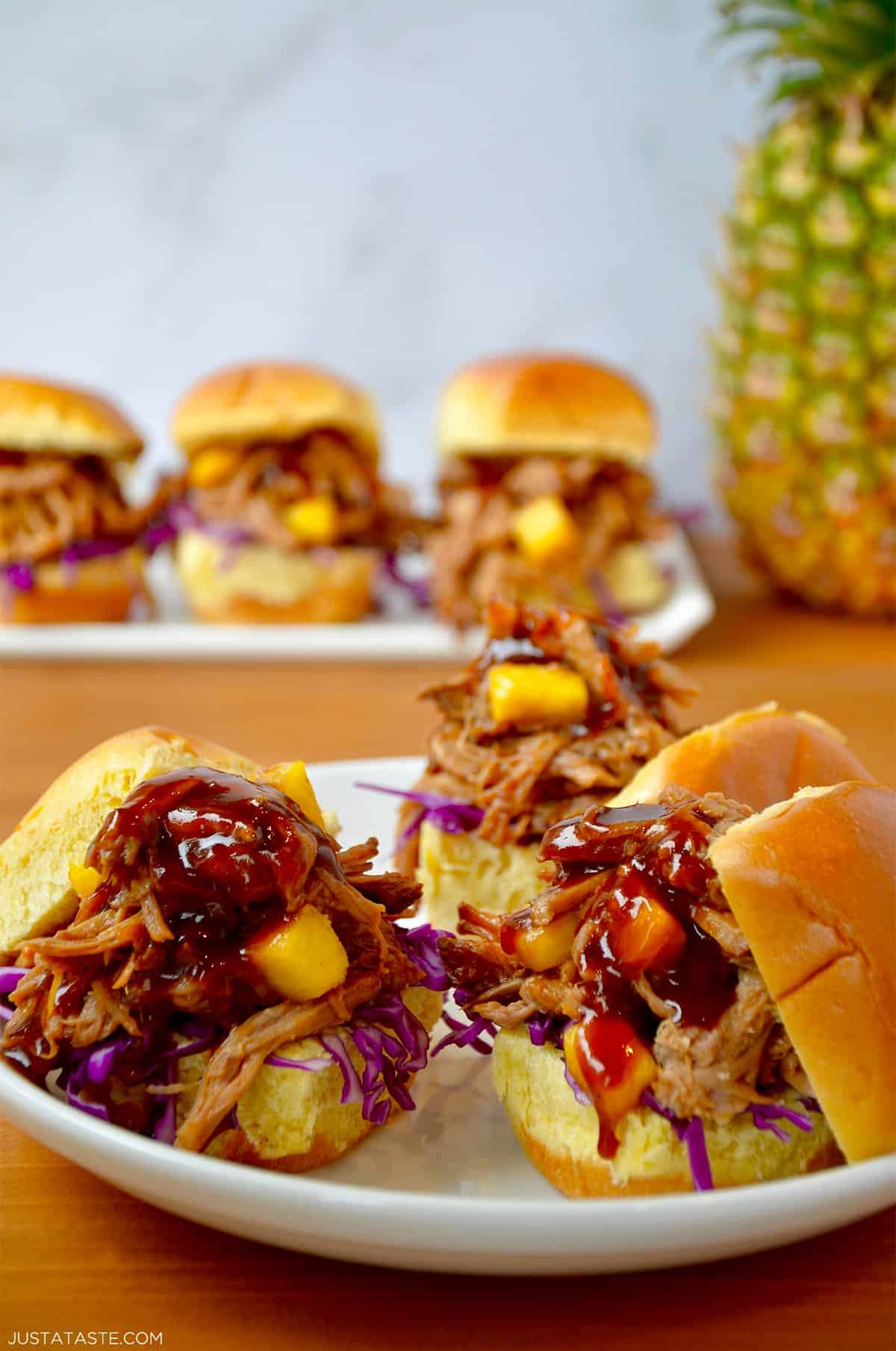 Slow cooker Hawaiian pulled pork with pineapple chunks and barbecue sauce on slider buns.