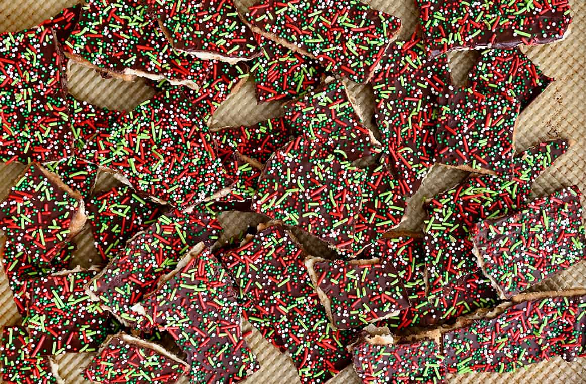 A top-down view of broken toffee pieces with Christmas sprinkles