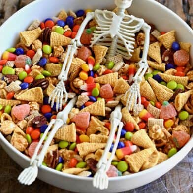 Easy Halloween snack mix with Chex cereal, pecans, candy corn, mini pretzels and M&Ms in a large serving bowl.