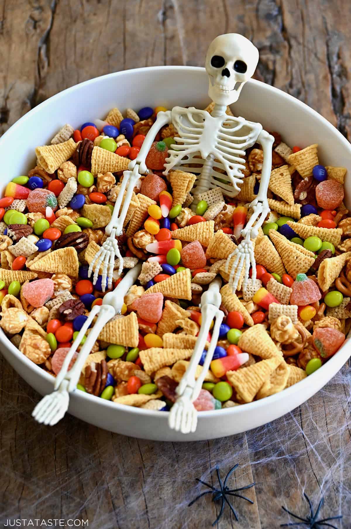 Easy Halloween snack mix with Chex cereal, pecans, candy corn, mini pretzels and M&Ms in a large serving bowl.