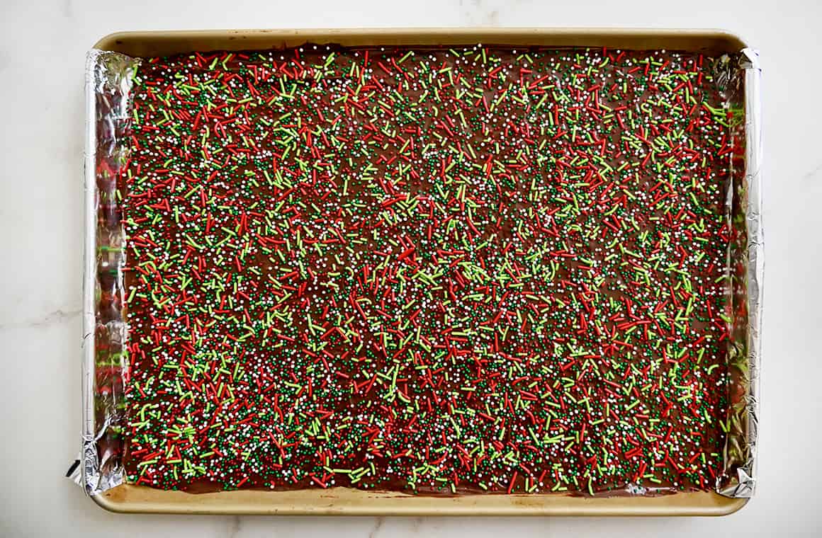 A top-down view of Christmas crack topped with festive holiday sprinkles 