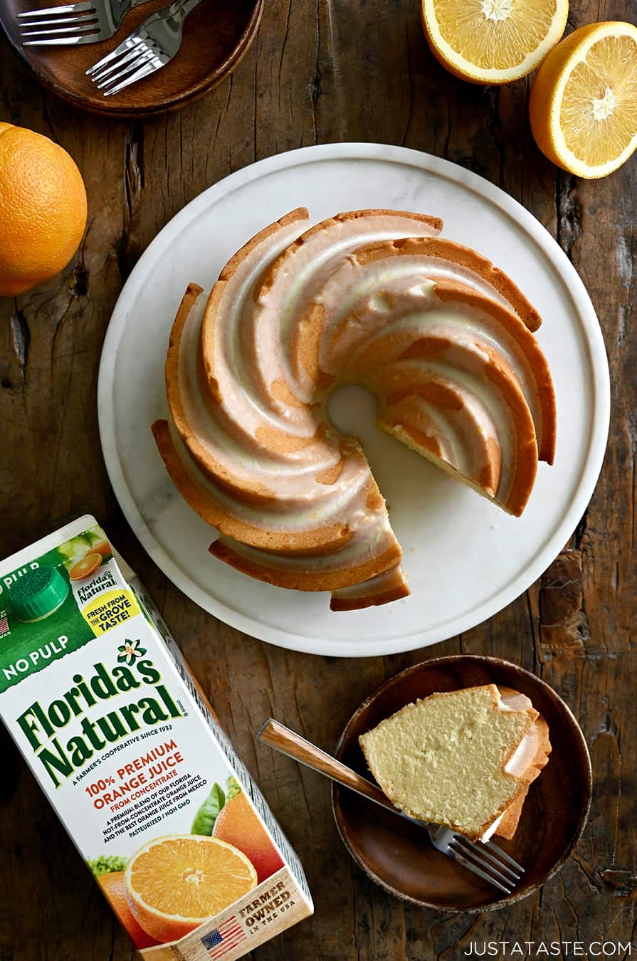 A top-down view of a pound cake with a citrus glaze next to a carton of Florida's Natural orange juice