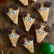 A top-down view of Reindeer Rice Krispie Treats with chocolate-covered pretzel "antlers" and candy eyes.