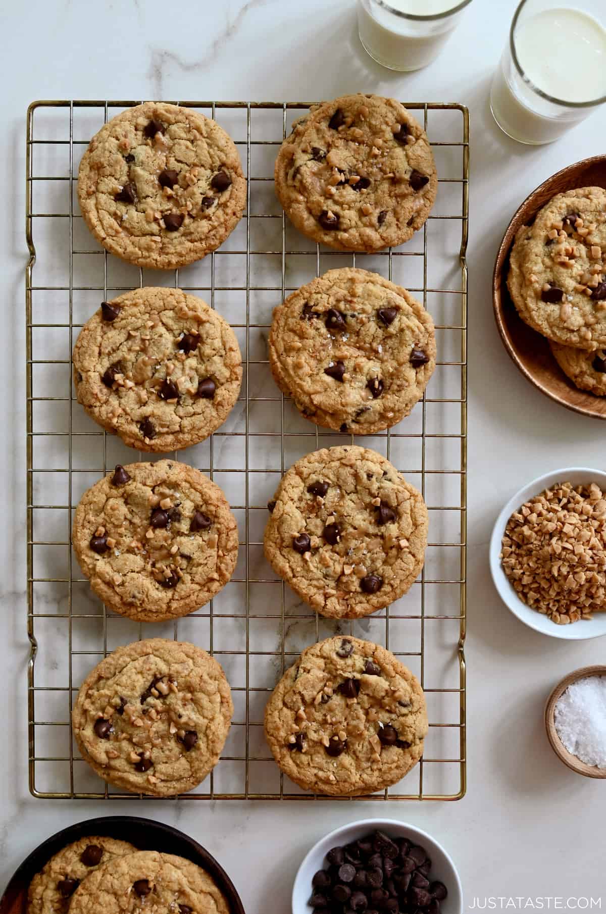 Toffee chocolate chip cookies garnished with large-flake sea salt cooling on a wire baking rack.