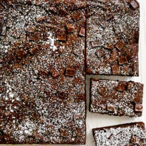 Homemade brownies studded with chocolate chunks dusted with powdered sugar.