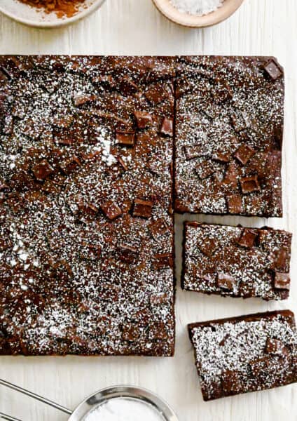 Homemade brownies studded with chocolate chunks dusted with powdered sugar.