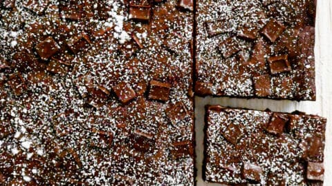 Homemade brownies studded with chocolate chunks dusted with powdered sugar.