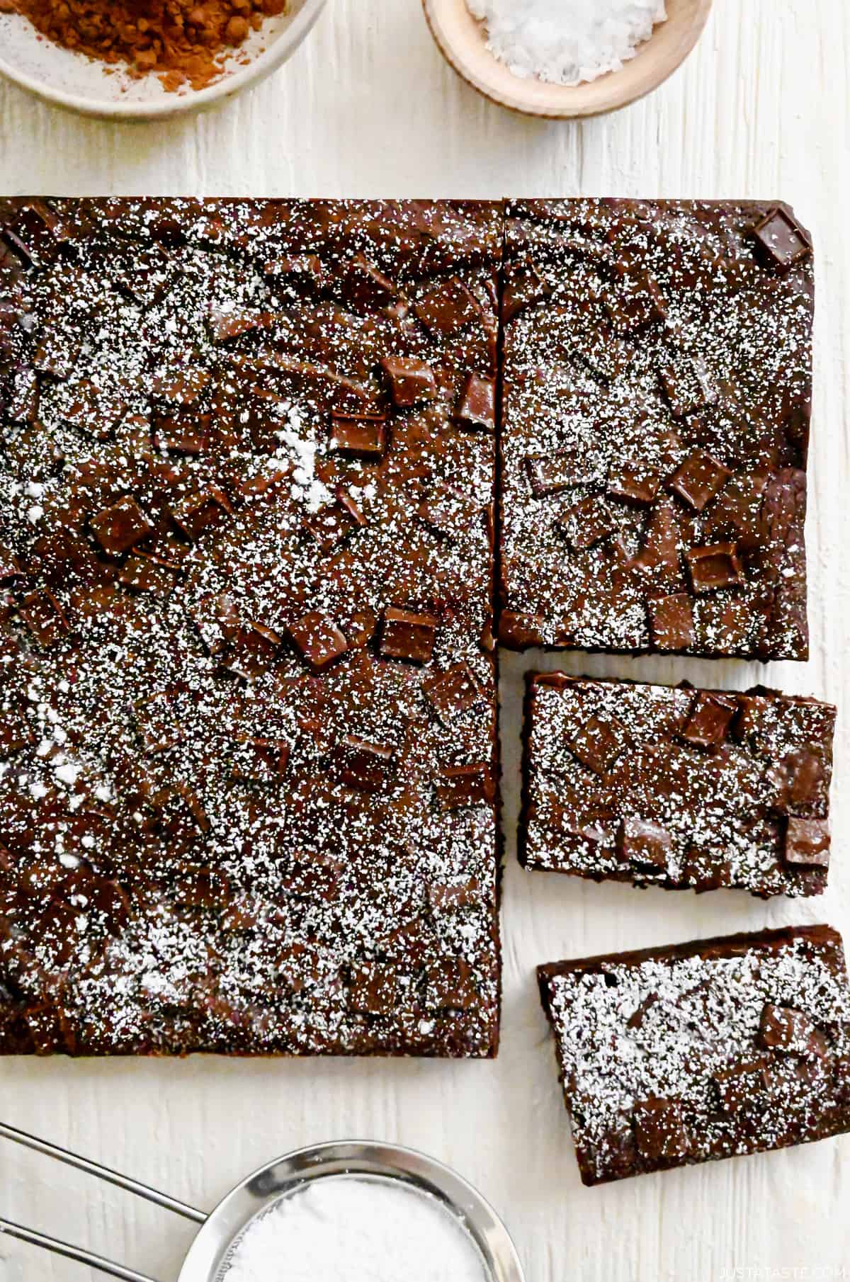 Homemade brownies studded with chocolate chunks dusted with powdered sugar.