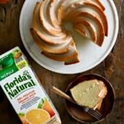 A top-down view of a pound cake with a citrus glaze next to a carton of Florida's Natural orange juice.